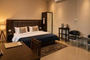 ein Hotelzimmer mit Bett, Tisch und Stühlen in der Unterkunft Bononi in Jorhat