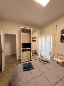 a white bedroom with a large bed and a television at Susy's Home Appartamento in centro in Corchiano
