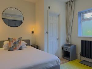a bedroom with a bed and a mirror and a window at Melbury Rooms & Studios in Exeter +45 photos