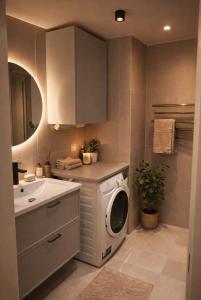 a kitchen with a washing machine and a sink at Modern studio with balcony in Stockholm