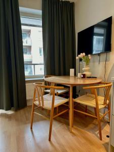 a dining room table with two chairs and a television at Modern studio with balcony in Stockholm