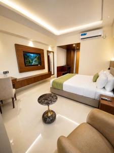 a hotel room with a bed and a couch and a table at The Royal Palace Uttara in Dhaka +52 photos
