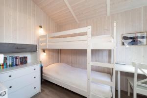 a bedroom with two bunk beds and a desk at Schmugglerstieg - Dorf Ferienhaus 03 in Priwall