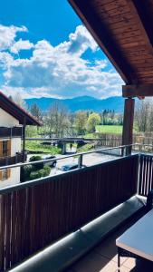 a balcony with a view of a river and mountains at FeWo Alpenglühen in Gmund am Tegernsee