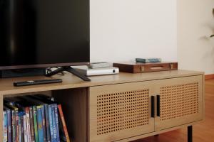 a tv sitting on top of a wooden entertainment center at Das Nomadenhaus - Garten, Grill, Nähe Köln in Bergheim