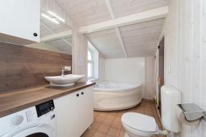 a bathroom with a toilet and a sink and a tub at Schmugglerstieg - Dorf Ferienhaus 03 in Priwall +26 photos