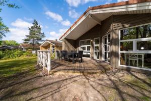 a home with a deck with a table and chairs at Schmugglerstieg - Dorf Ferienhaus 03 in Priwall