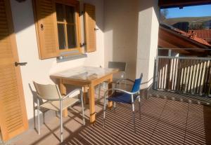 a balcony with a wooden table and two chairs at FeWo Alpenglühen in Gmund am Tegernsee