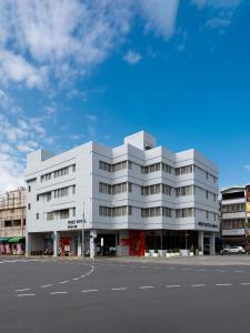 a white building on the side of a street at West Hotel in Puli