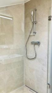 a shower with a shower head in a bathroom at FeWo Alpenglühen in Gmund am Tegernsee