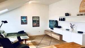 a living room with a couch and a tv at FeWo Alpenglühen in Gmund am Tegernsee