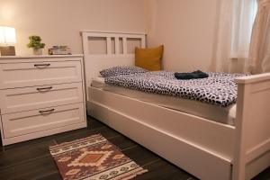 a small bedroom with a bed and a dresser at Dunavirág Vendégház in Pilismarót