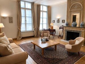 a living room with a fireplace and a table at Hotel Le Dixseptième in Brussels