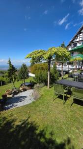 a picnic table in the grass next to a building at Berghof Grüner Baum in Sasbachwalden