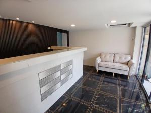 a waiting room with a chair and a television at Yoosabai Hostel And Guesthouse in Bangkok