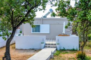 a house with white walls and a tree at Christiana's House in Artemida