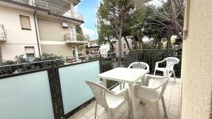 a balcony with a table and chairs and a building at M314 - Marcelli, comodo trilocale a 200mt dal mare in Marcelli