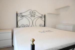 a white bed with a metal headboard in a room at M314 - Marcelli, comodo trilocale a 200mt dal mare in Marcelli