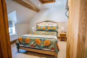a bedroom with a bed with a floral bedspread at March Hare Cottage in Bretforton in Bretforton