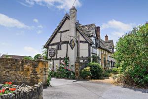an old stone building with flowers in front of it at March Hare Cottage in Bretforton in Bretforton