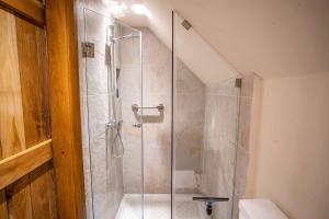 a shower with a glass door in a bathroom at March Hare Cottage in Bretforton in Bretforton +8 photos
