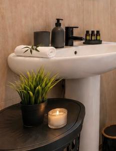 a bathroom sink with a candle and a plant at Cocomelo apts 3 luxury in Heraklio +29 photos