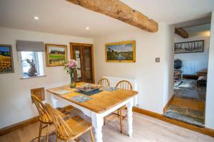 a dining room with a wooden table and chairs at March Hare Cottage in Bretforton in Bretforton