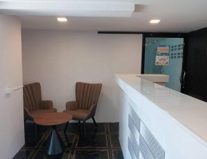 a bar with two chairs and a table in a room at Yoosabai Hostel And Guesthouse in Bangkok