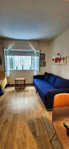 a living room with a blue couch and a table at Les Flors !2minutos de la playa! in Lloret de Mar