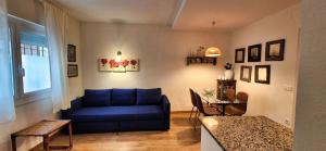 a living room with a blue couch and a table at Les Flors !2minutos de la playa! in Lloret de Mar