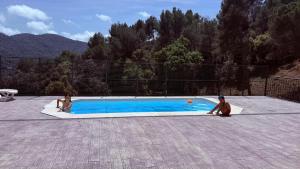 two people are sitting in a small swimming pool at Espacio Kybalion in Argentona +38 photos