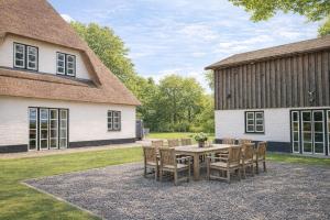a patio with a table and chairs in front of a barn at Alte Wassermühle Nord in Börm