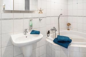 a white bathroom with a sink and a bath tub at Ferienwohnung Auszeit in Berlin +21 photos