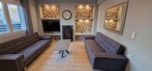 a waiting room with couches and a clock on the wall at Villa Little John in Skala Rachoniou