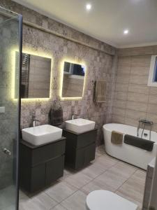 a bathroom with two sinks and a bath tub at Villa Little John in Skala Rachoniou +13 photos