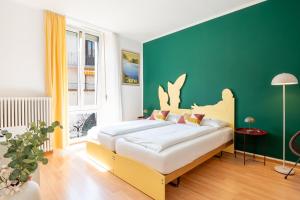 a bedroom with a large bed with a green wall at Residenza Motta - Boutique Apartments in Locarno