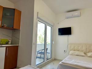 a bedroom with a bed and a sliding glass door at Garden studio apartmans in Dobra Voda