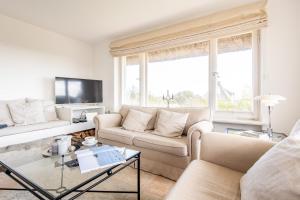 a living room with a couch and a table at Düünhuus in Hörnum