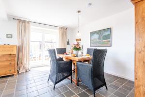 a dining room with a wooden table and chairs at Düünhuus in Hörnum