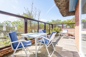 a patio with a table and chairs on a deck at Düünhuus in Hörnum