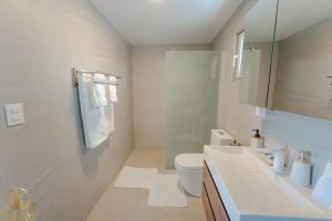 a white bathroom with a toilet and a sink at Ideal accommodation for couples Sosúa, Santa Fe in Sosúa +25 photos