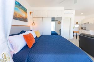 a bedroom with a blue bed with two orange pillows at Ideal accommodation for couples Sosúa, Santa Fe in Sosúa