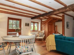 a living room with a blue couch and a table at Pylemoor Cottage in Tiverton