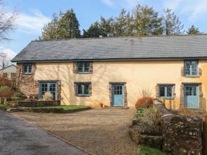 a large yellow house with a brick driveway at Pylemoor Cottage in Tiverton