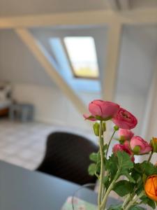 a vase filled with pink flowers on a table at Buschhaus Whg 1 in Krummhörn