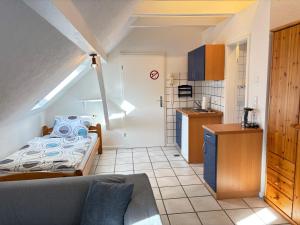 a small room with a bed and a kitchen at Buschhaus Whg 1 in Krummhörn +9 photos