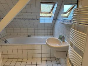 a bathroom with a sink and a bath tub at Buschhaus Whg 1 in Krummhörn