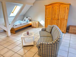 a living room with a couch and a chair at Buschhaus Whg 2 in Krummhörn