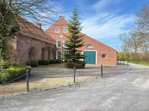 a brick house with a tree in front of it at Buschhaus Whg 2 in Krummhörn