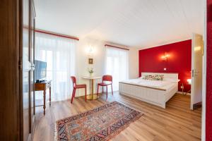 a bedroom with a white bed and a red wall at Residenza Motta - Boutique Apartments in Locarno +11 photos